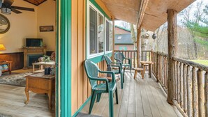 A wooden deck with outdoor seating, a fireplace, and a television in the background. - 2 Mi to Lake Champlain: Cabin w/ River Access! (Peru)