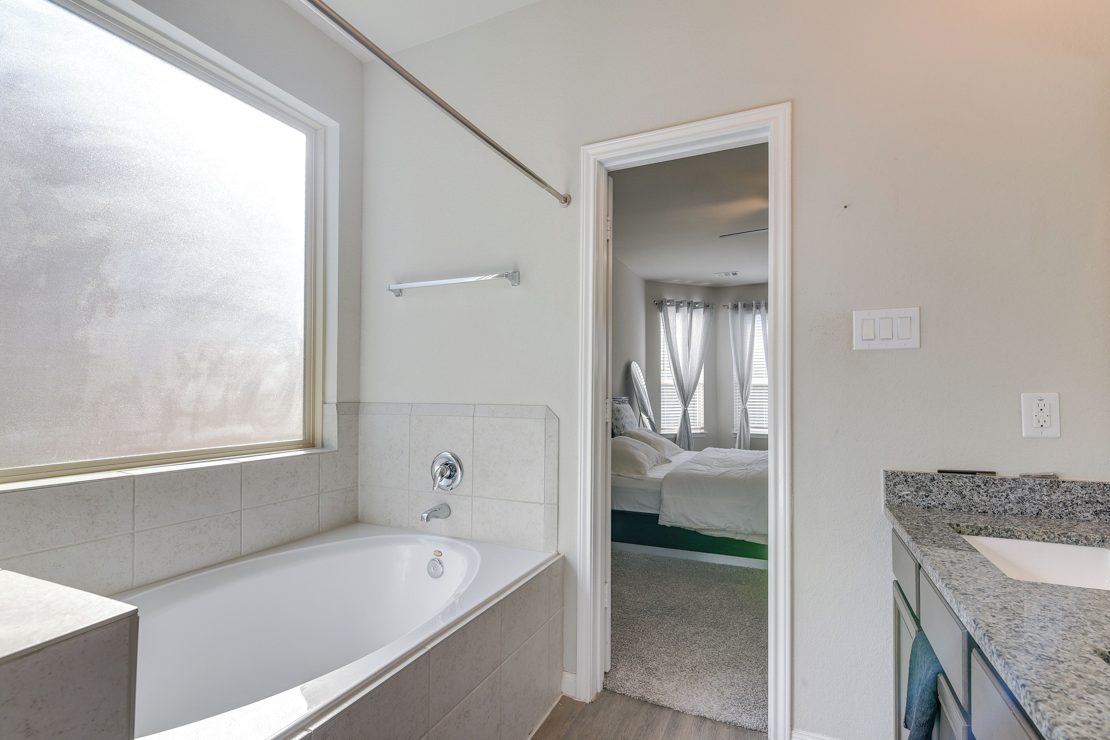 A modern bathroom with a bathtub, a shower area, and a sink.