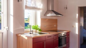 Een moderne keuken met houten kastjes, een roestvrijstalen afzuigkap en een inbouwoven.