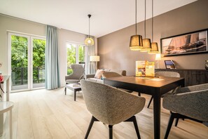 A modern dining area with a wooden table, grey upholstered chairs, and pendant lighting.