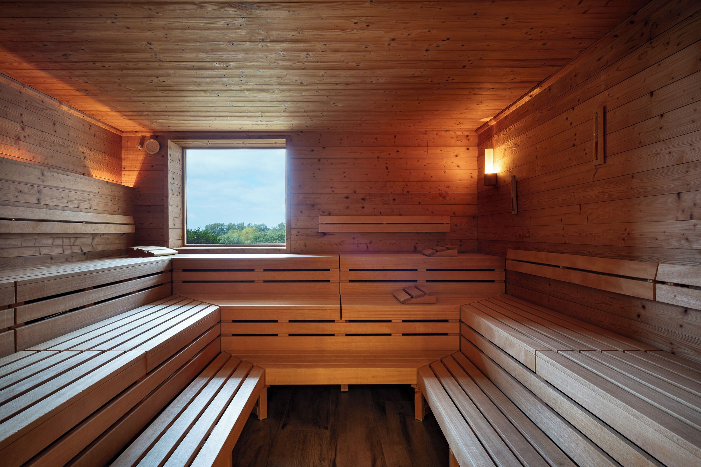 A sauna with wooden benches and a skylight.