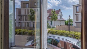 Vista desde una ventana de una zona residencial con edificios modernos, un coche aparcado y una farola.