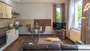 Una cocina moderna con comedor, televisor y sofá en la sala.
