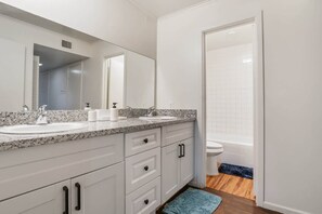 A bathroom with two sinks, a large mirror, and a bathtub. - Hoff Gardens 38 - 1BR/1BA - Downtown Lubbock (Lubbock)