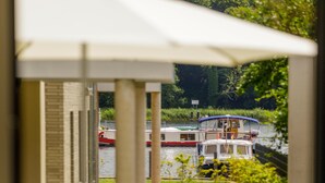 A canal view with boats, a building, and greenery. - "Nordlicht" Vacation Rental in the Island Town of Malchow (Malchow)