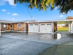 A two-story house with a garage and a covered driveway. - Water Edge Coast-Guard Cottage-Panorama View- (Port Angeles)