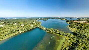 An aerial view of a large body of water surrounded by dense forest.
