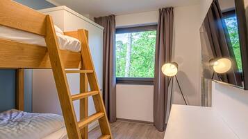 Habitación con literas, una escalera de madera, escritorio, espejo y ventana con cortinas.