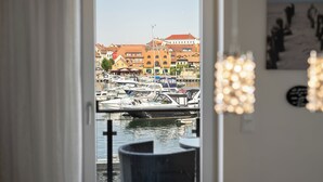 A view through a doorway to a marina with boats, buildings, and a chandelier. - Vacation apartment with water view on the 1st floor of the Hafenresidenz Waren (Waren (Müritz))