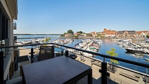 Un balcon donnant sur une marina et sur des bâtiments en arrière-plan.