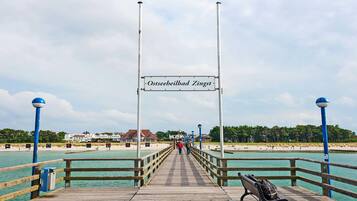 Laituri, jossa on kyltti, jossa lukee ”Ostseeheilbad Zingst”, ja joka johtaa rannalle.