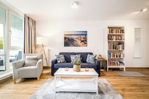 A living room with a sofa, coffee table, and bookshelf.