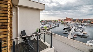 Parveke, jolta avautuu näkymä venesatamaan ja taustalla näkyviin rakennuksiin.