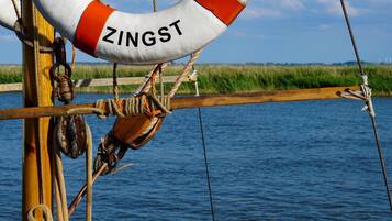 Ein Rettungsring mit dem Schriftzug "ZINGST", an einer Holzkonstruktion in Wassernähe befestigt.