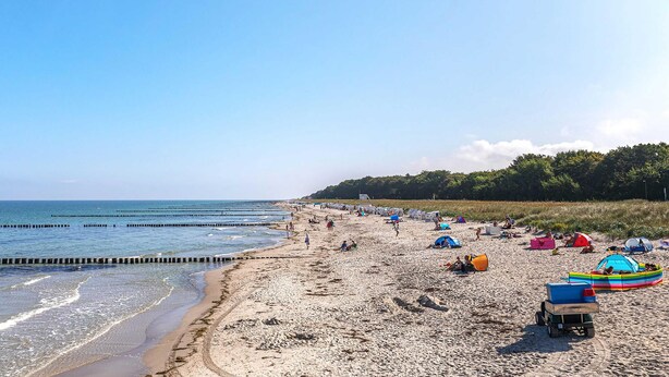 A beach with tents and a boat.