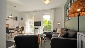 Una sala moderna con un sofá, una mesa de comedor y un televisor.