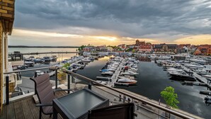 A marina with boats docked, a waterfront view, and buildings in the background. - Vacation apartment feel-good oasis with panoramic views and right next to the spa (Waren (Müritz))