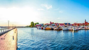 Un paseo marítimo con una hilera de edificios coloridos y barcos amarrados al muelle.