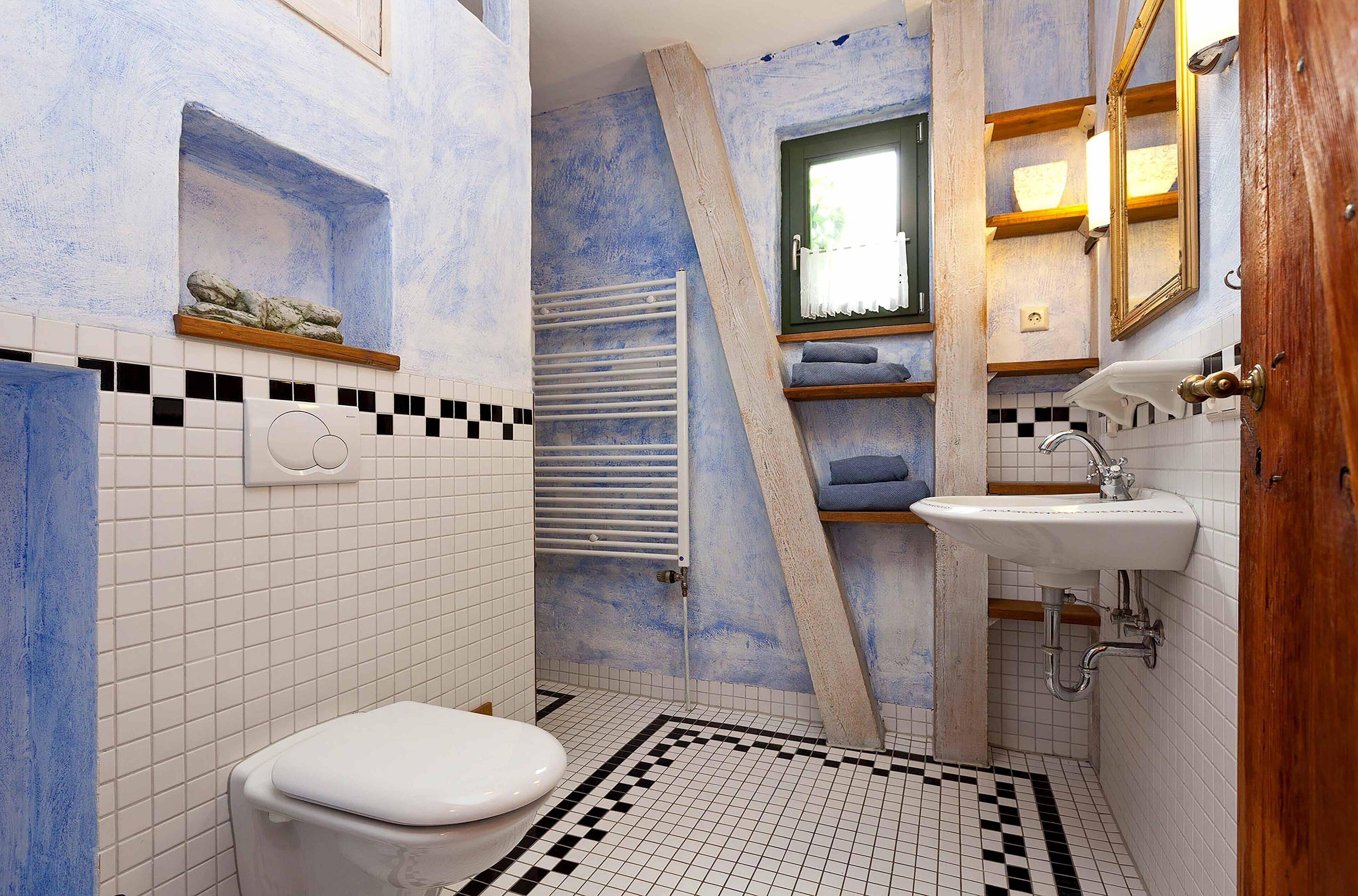 A bathroom with a white toilet, a sink, and a shower area.
