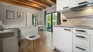 Eine moderne Küche mit weißen Schränken und einer Holzbalkendecke.