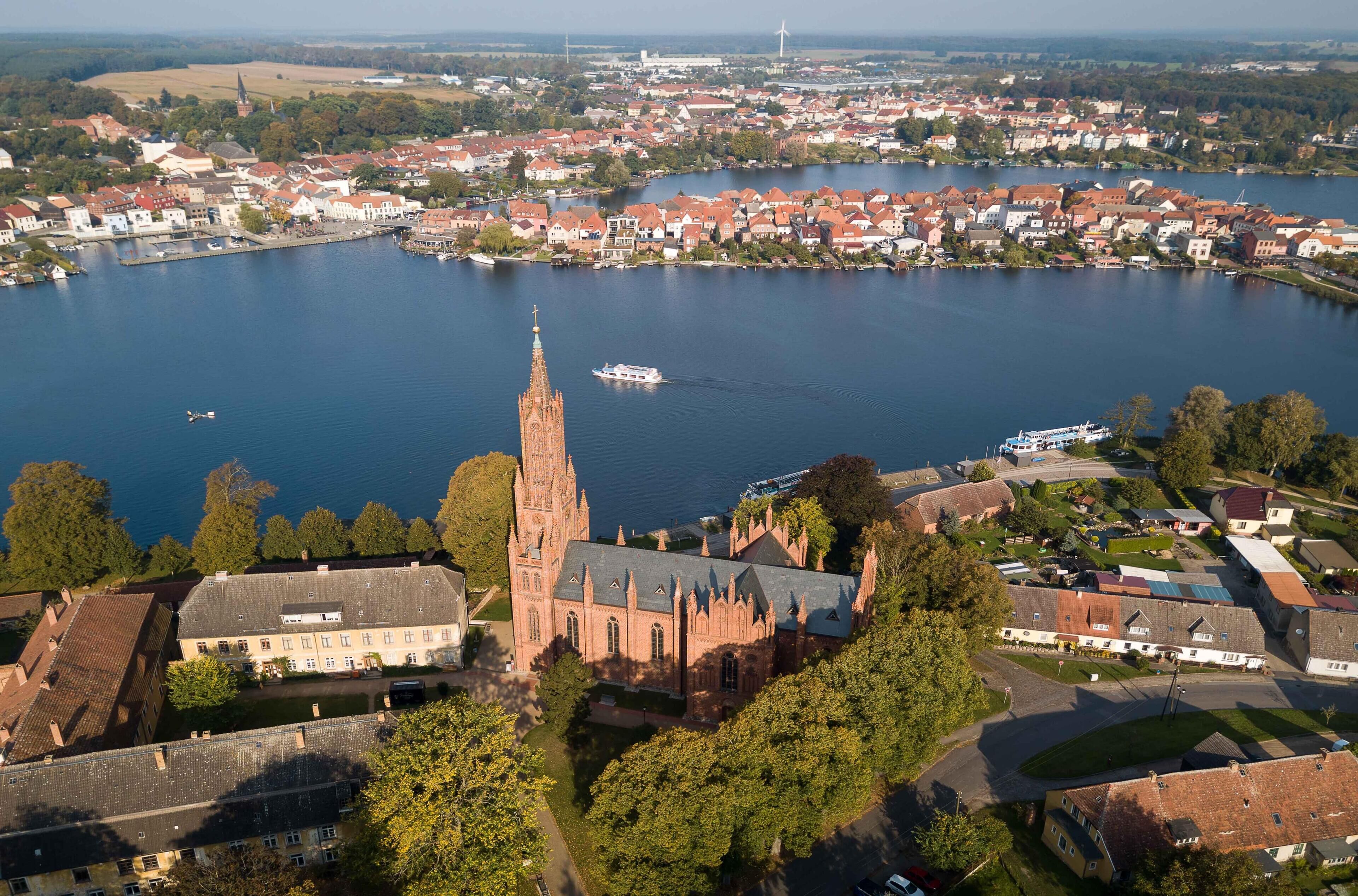 An aerial view of a town with a prominent church and a body of water.