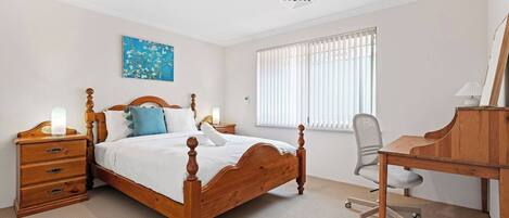 This bright and inviting bedroom offers a perfect blend of comfort and functionality, ideal for both relaxation and productivity.