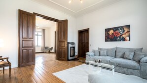 Un salon moderne avec un canapé gris, une table basse en verre et un plancher en bois.