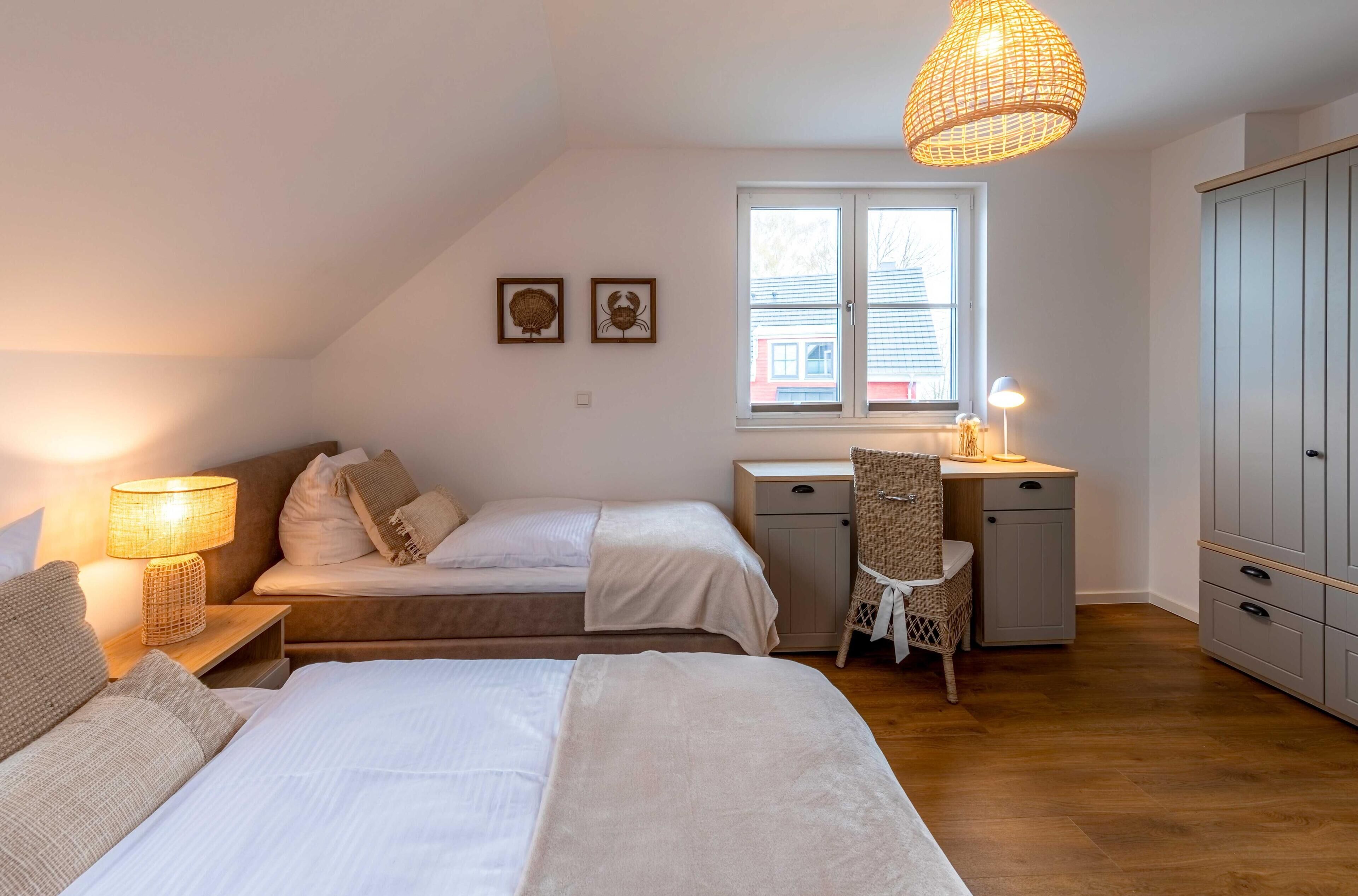 Une chambre avec deux lits, un bureau, une chaise, une armoire et une fenêtre.