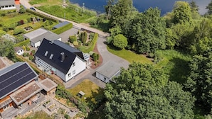 Eine Vogelperspektive zeigt eine Wohngegend mit Häusern, einer Solaranlage und einem See.