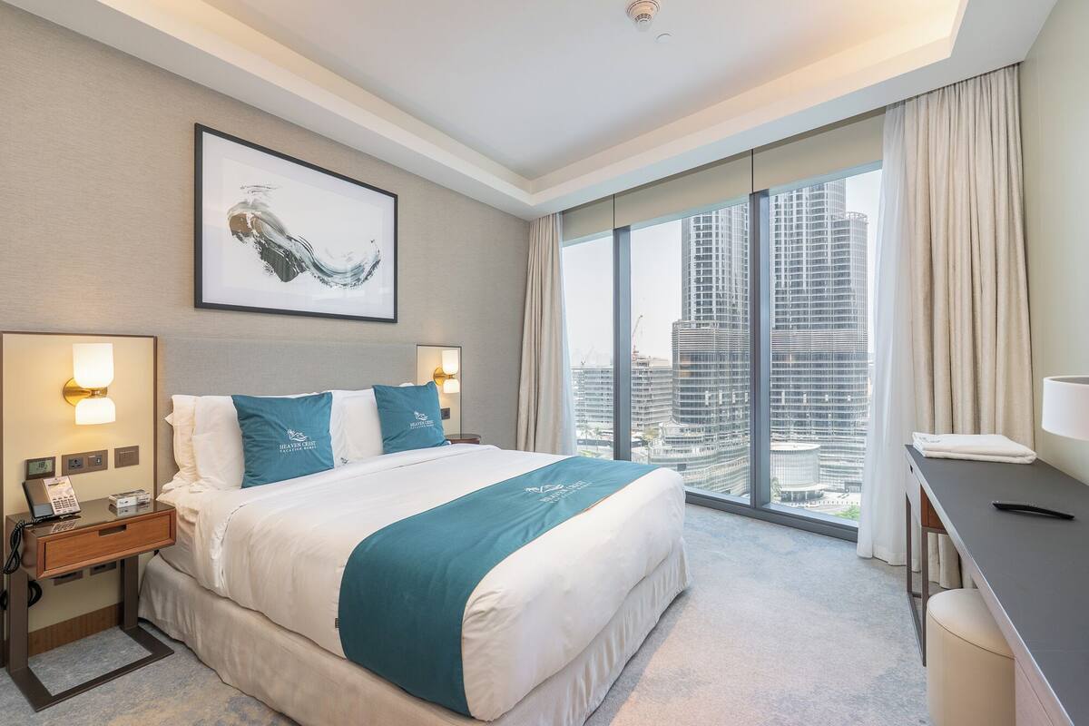 Une chambre d’hôtel avec un grand lit, un bureau et une vue sur la ville.