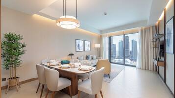 Un espace repas moderne avec une table ronde, des chaises blanches et un luminaire suspendu.