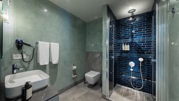 A modern bathroom with a freestanding bathtub, a toilet, and a glass-enclosed shower area.