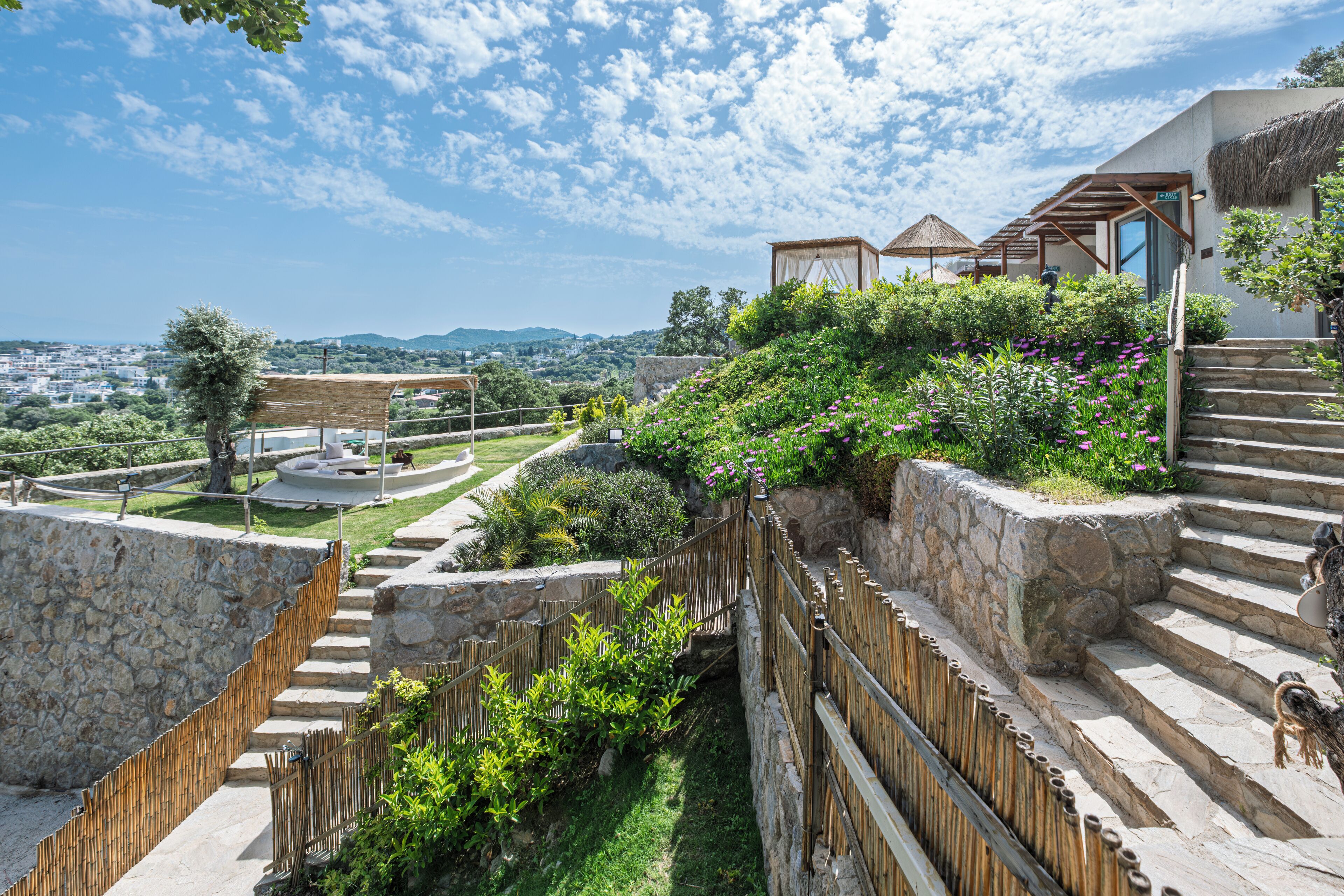 Una escalera de piedra que conduce a un edificio con tejado de paja y vistas de la ciudad.