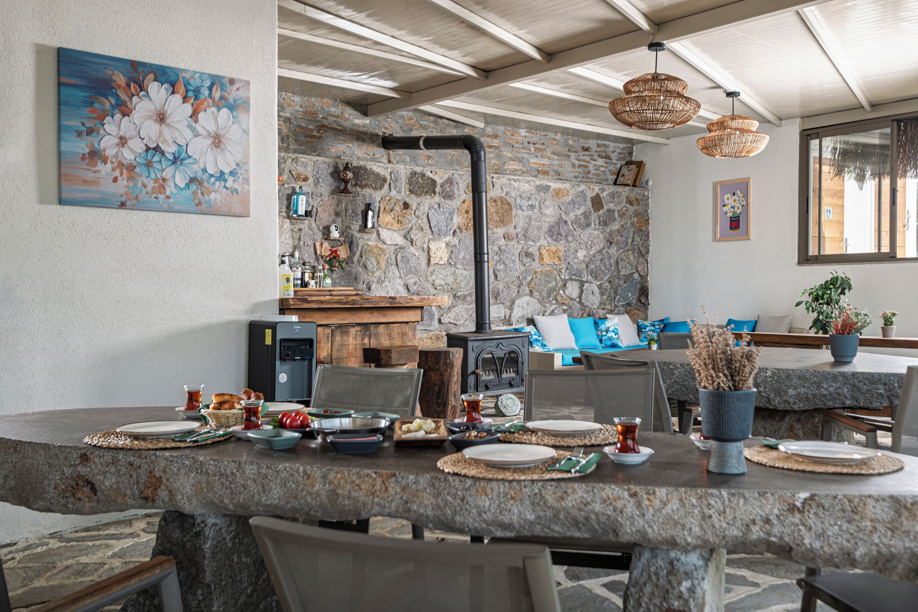 Un comedor rústico con una pared de piedra, una chimenea y una encimera de piedra.