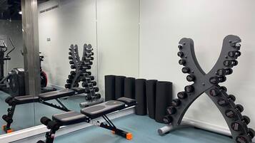 Ett gym med utrustning för styrketräning, träningsbänkar och träningsbollar.