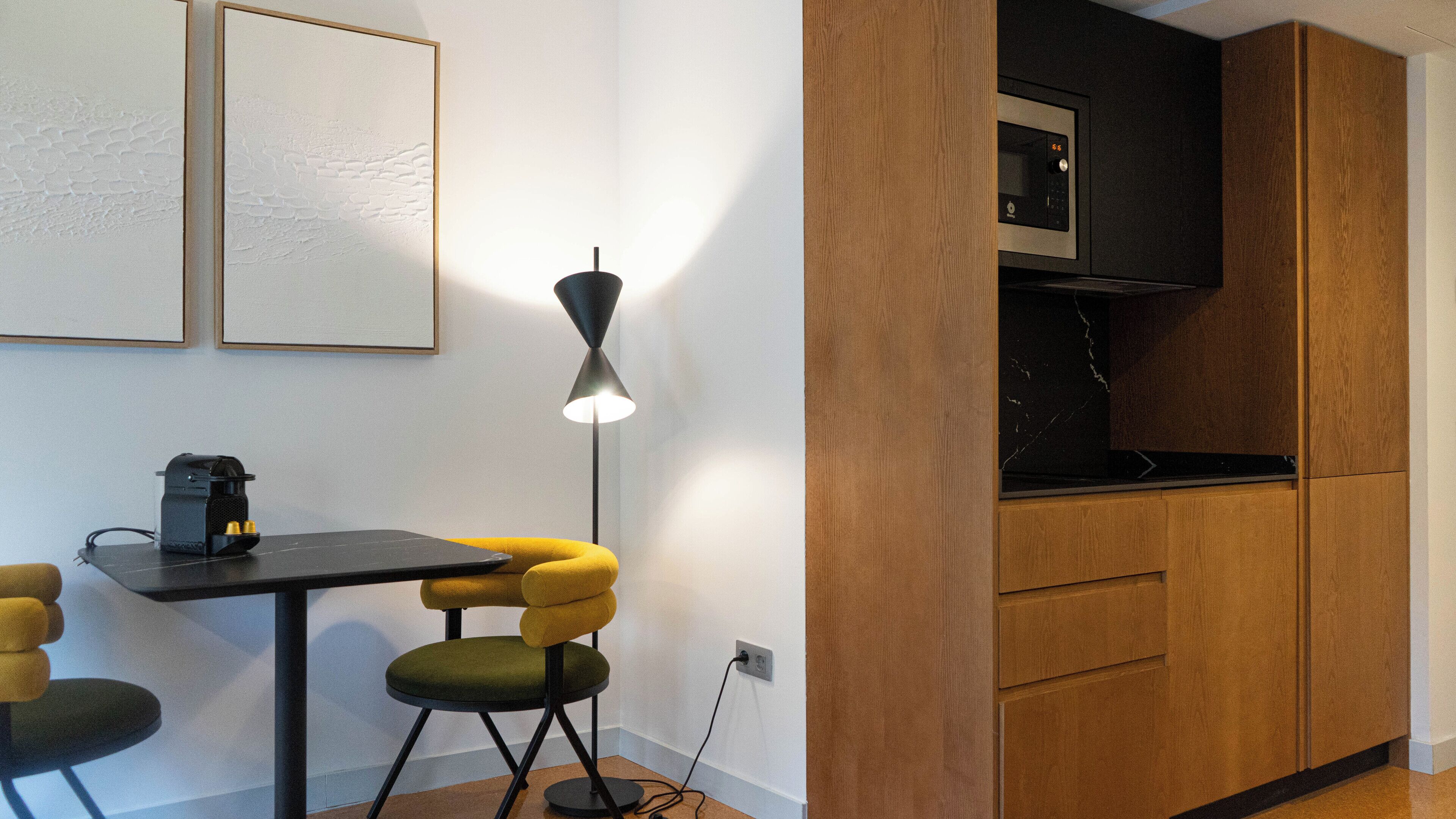 Une cuisine compacte équipée d’un four à micro-ondes, d’une petite table et de deux chaises.
