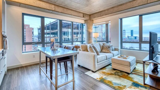 A modern apartment with a dining area, sofa, and TV. - Luxury Apt Kendall Sq with Amenities (Cambridge MA)