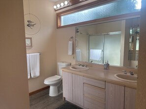 A bathroom with two sinks, a toilet, a mirror, and a towel rack. - Soaring Seabird - Yachats Ocean View with Hot Tub (Yachats)