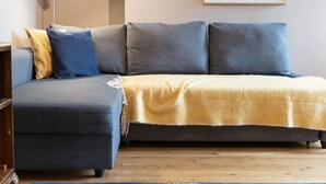 A modern living room with a sofa and a small table, a lamp, and a framed picture on the wall. - Host Stay Waterloo Apartment (Hove)