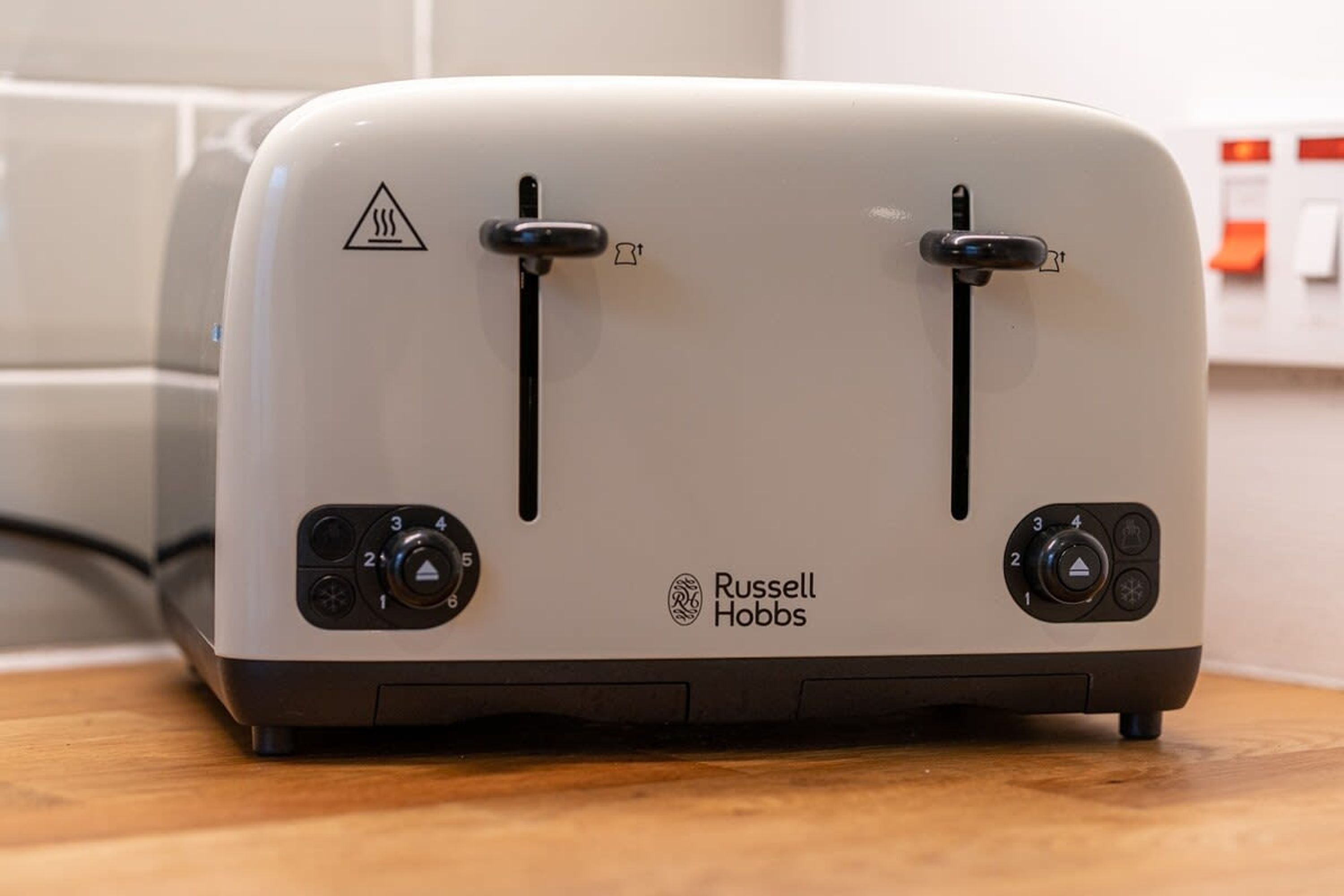 Ein weißes Russell Hobbs Toaster mit zwei schwarzen Griffen und Bedienelementen an der Vorderseite.