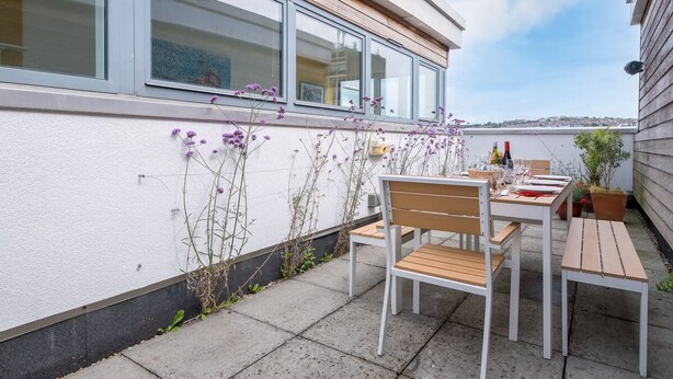 An outdoor patio with a table and chairs, a potted plant, and a view of the city. - Host Stay Kingscote Townhouse (Brighton)