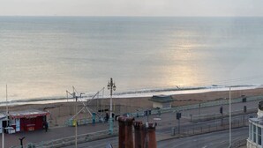 A coastal road with a beach in the background, a red kiosk, and a lamp post. - Host Stay Sea View on Manchester Road (Brighton)