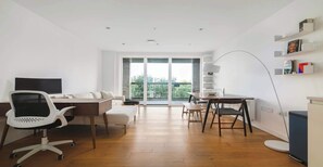 Un apartamento moderno con comedor, sofá, televisor y balcón con vistas.