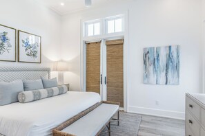 A bedroom with a bed, bedside table, lamp, and artwork. - Mischievous Mermaid|Easy Beach Access|Private Pool|Game Room|Golf Cart (Seagrove Beach)