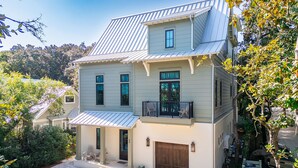 A two-story house with a garage, a front porch, and a small balcony.