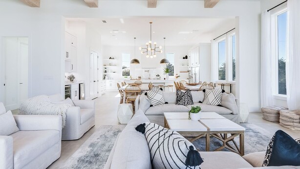 A modern living room with a sofa, coffee table, and dining area.