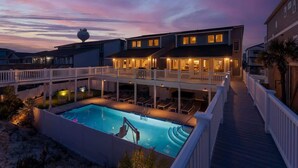 Un bâtiment à deux étages doté d’une piscine et d’une terrasse couverte.