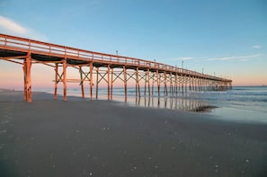 A pier extending into the water with a clear sky above. - Oceanfront Free EV charger & GolfCart, Pool (Ocean Isle Beach)