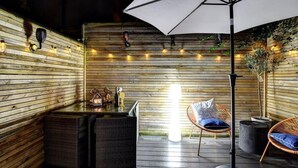 A wooden deck with a table, chairs, and an umbrella. - Host & Stay | Bedford Place Hideaway (Brighton and Hove)