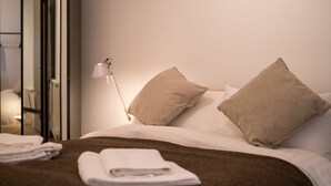 A neatly made bed with a brown blanket, two beige pillows, and a folded white towel on the side. - Host & Stay | Osbourne Rest (Brighton and Hove)